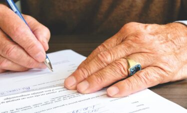 Una persona esta firmando un documento - Parte Legal